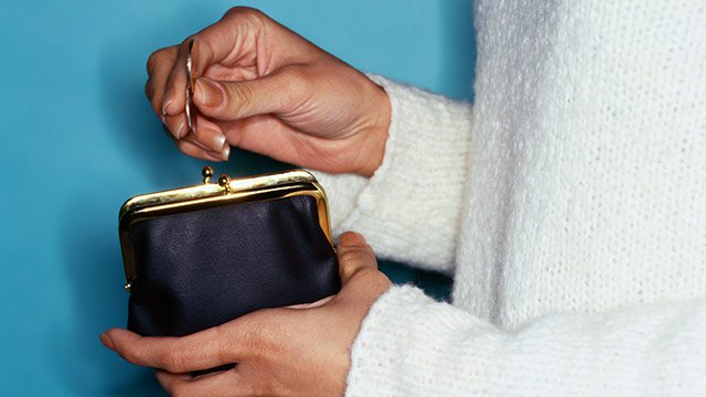 A woman's hands holding a small change wallet.