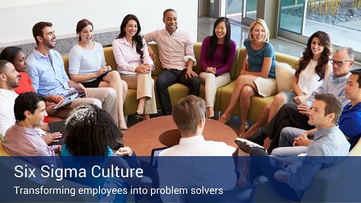 A group of co-workers sitting in a circle talking about the culture of six sigma.