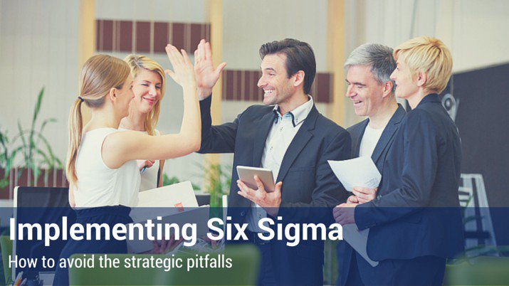 Group of co-workers high-fiving each other after implementing six sigma in the workplace.