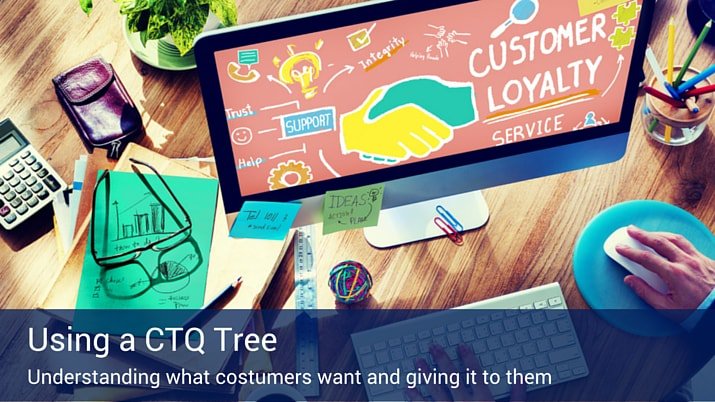 Someone using a desktop computer with a colorful graphics on the screen that say "Customer Loyalty", with a banner that reads "Using a CTQ Tree".