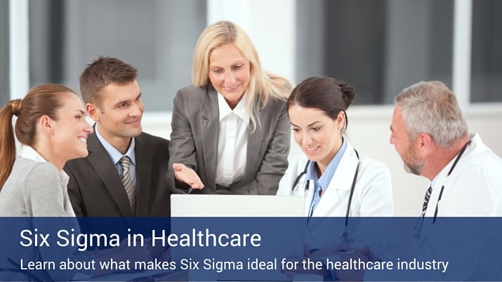 Four healthcare professionals looking at a computer together with a blue banner that reads "six sigma in healthcare".
