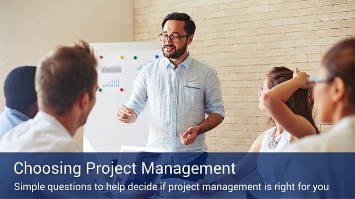 A man giving a presentation about choosing project management to a small group of four co-workers.