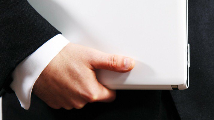 A pair of hands holding a white binder.