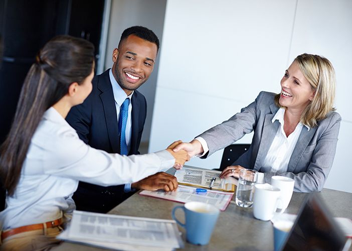 HR Business Partner depicted as a businessman joined by two business women shaking hands across a table.