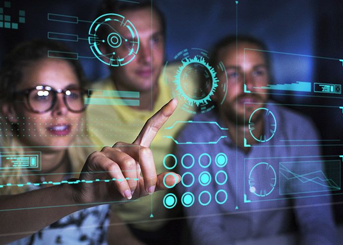 Three people looking at a holographic touch screen depicting the project management disruption compressor.