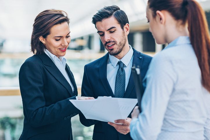 Office workers discussing the stipulations of a document