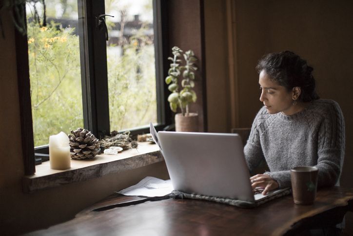 Mixed-race businesswoman works at home on computer