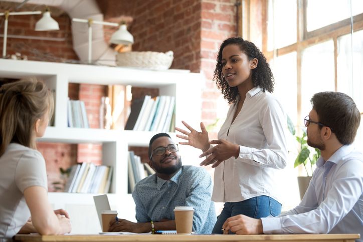 African-american manager communicating a message to her team in an office.