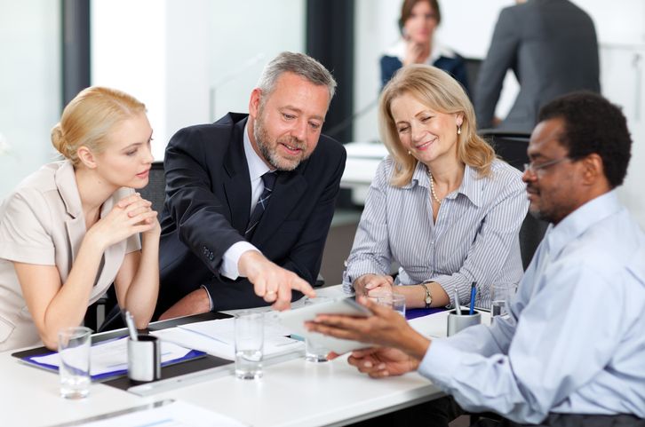 Team leader discusses a project with their team in an office.