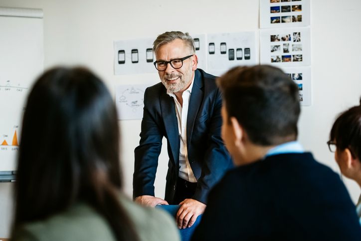 Mature businessman speaking during an informal meeting to younger colleagues