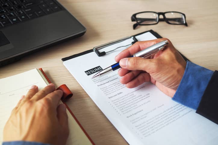 Man writing a resume in an office.