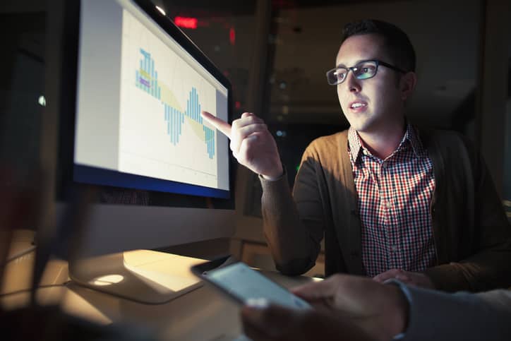 Work colleague discussing project details on computer screen