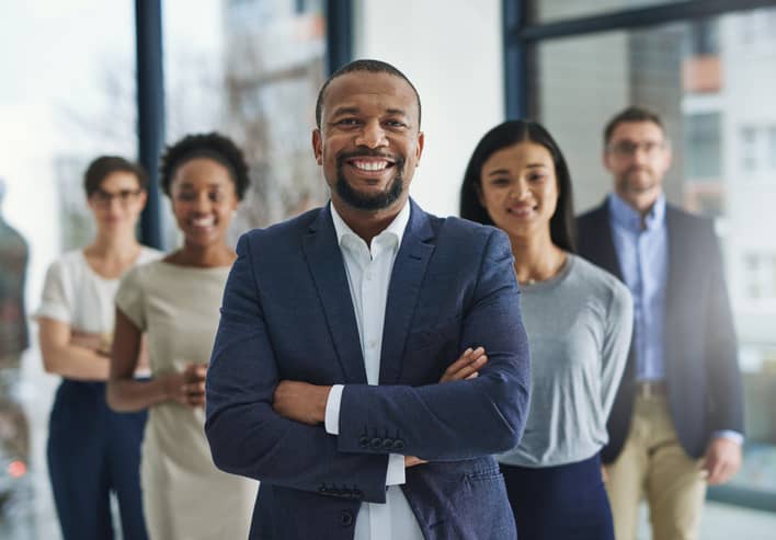 Diversity manager standing in front of team of diverse business professionals.