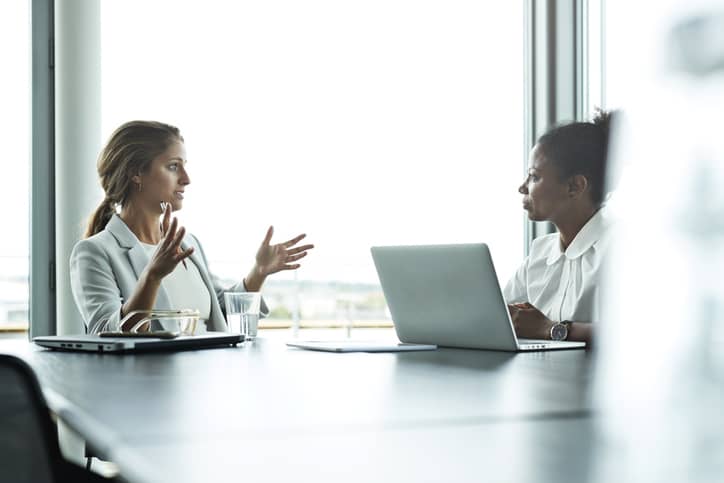 Concept of a Compensation and Benefits Manager sitting with an employee in an office setting